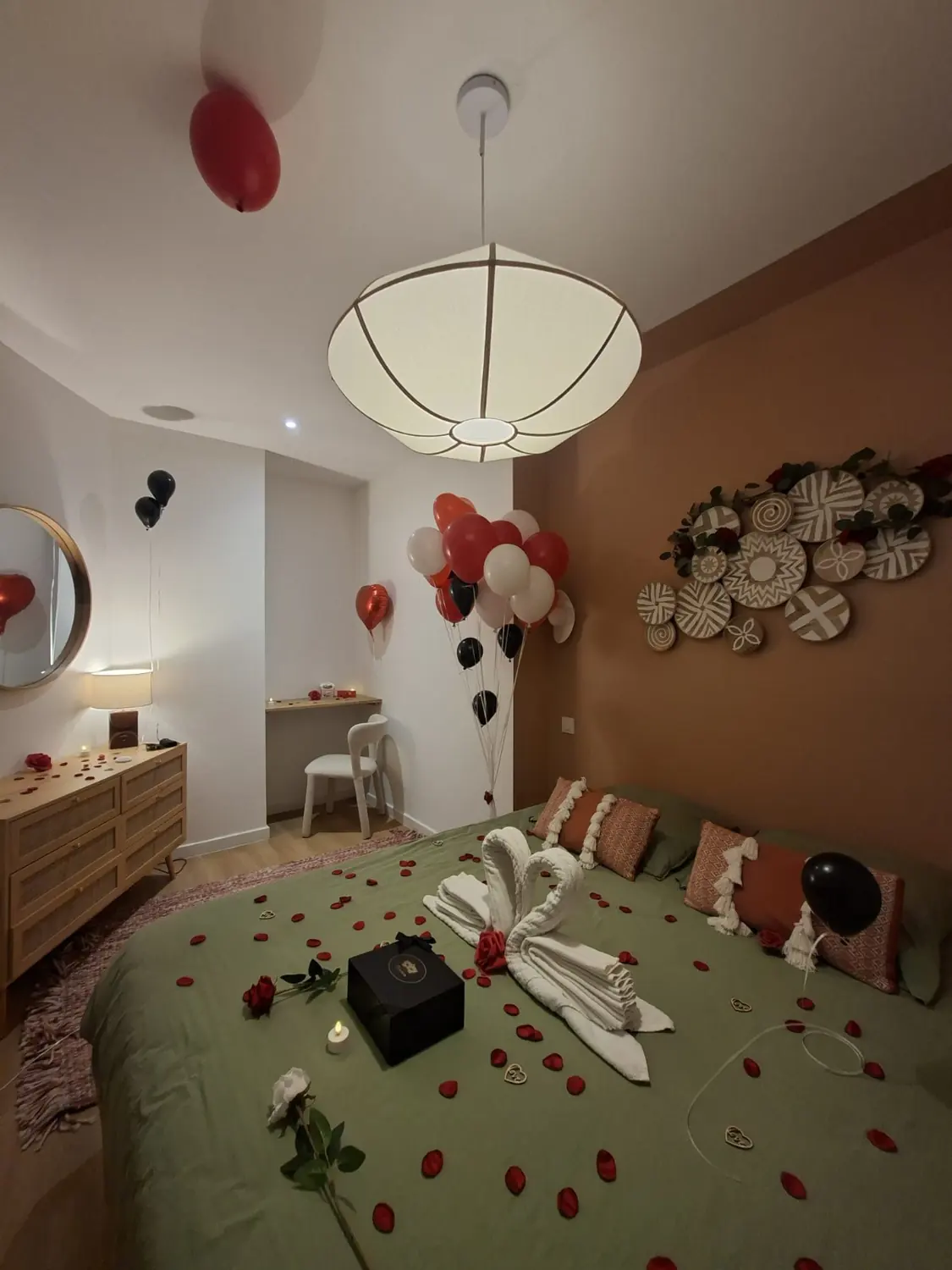 Chambre romantique en soirée, lit vert sauge, coiffeuse et grand miroir rond